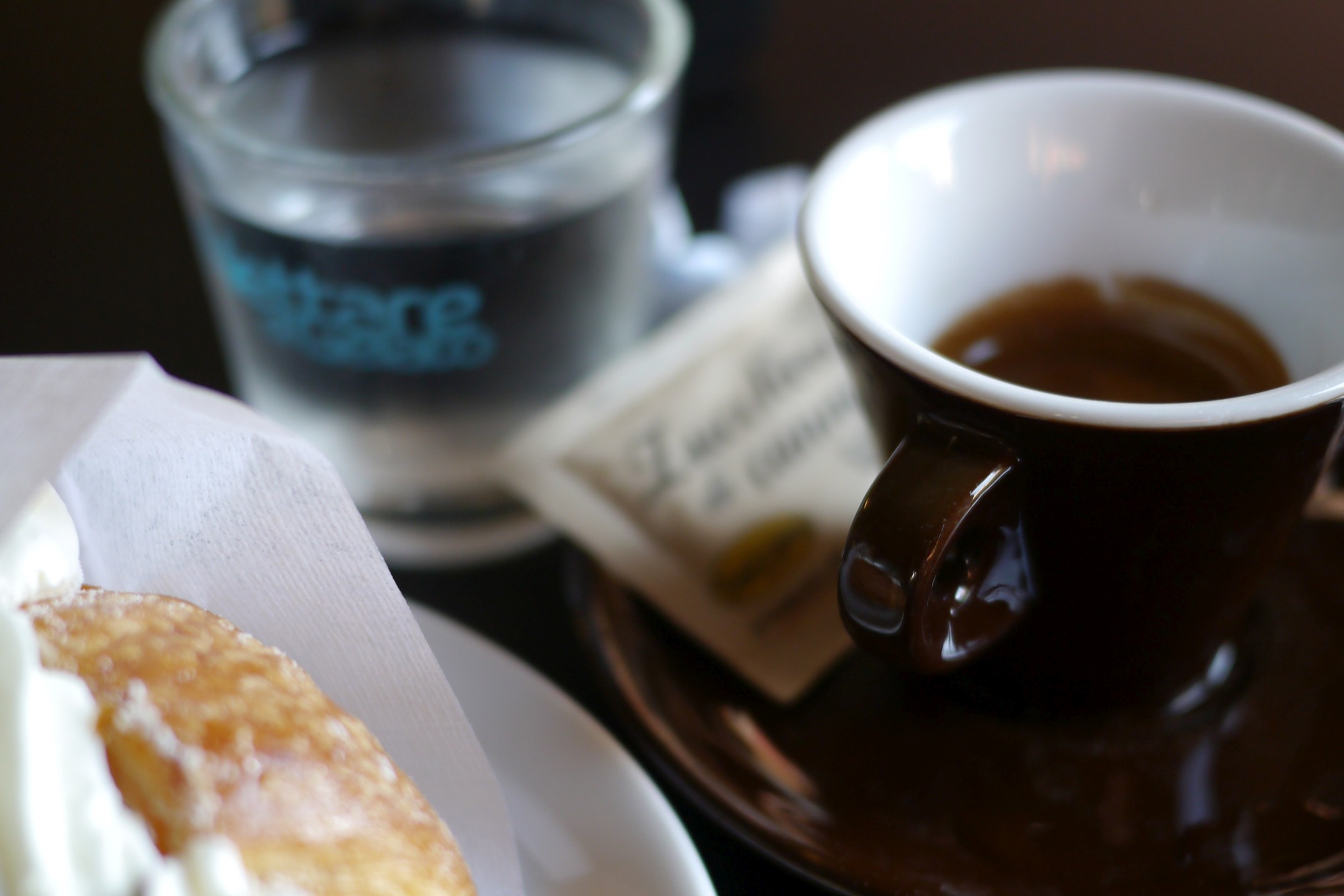 Caffè mit Wasser und süßem Gebäck in einer Bar